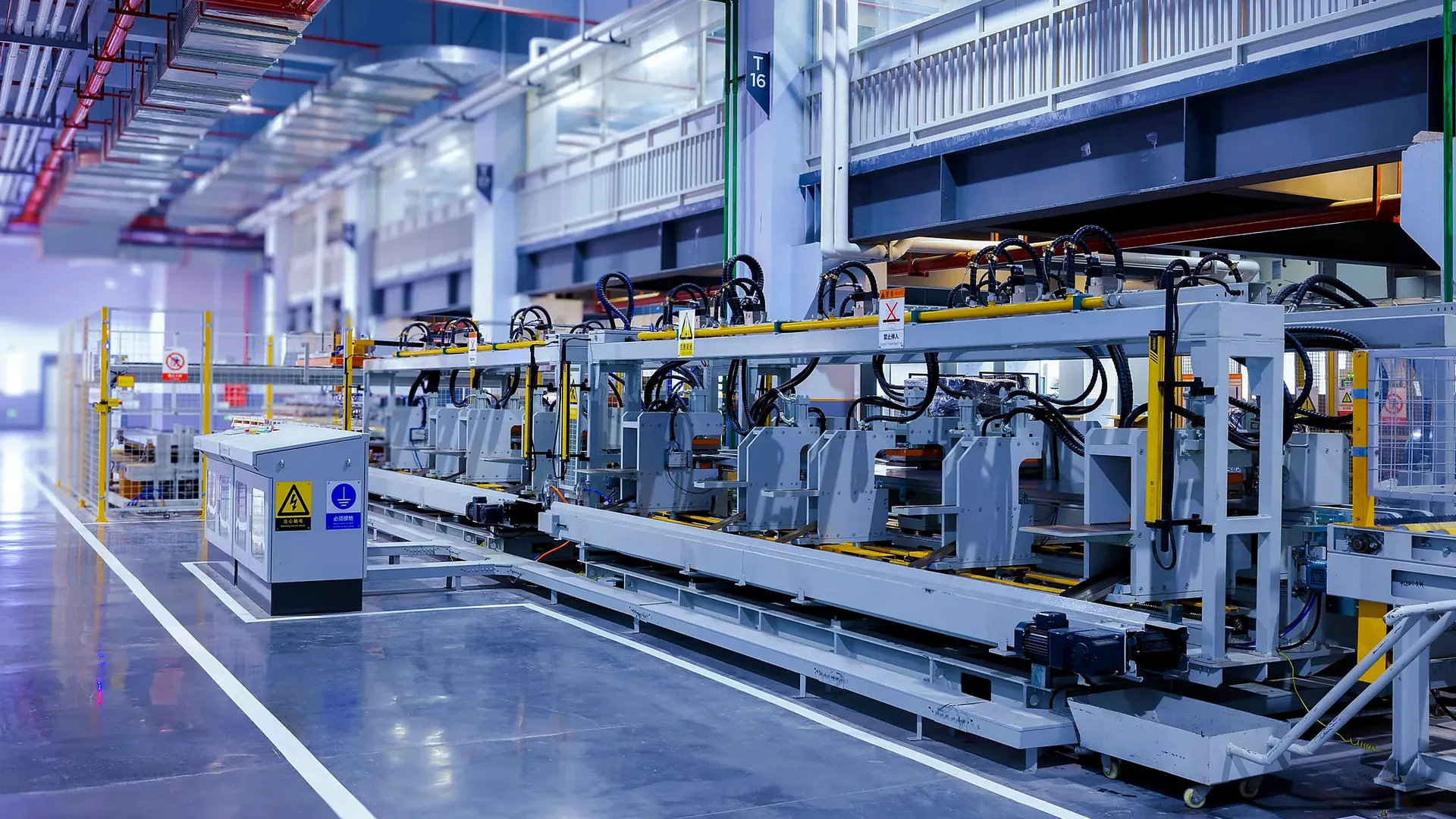 Automated machinery and conveyor frames inside a factory.
